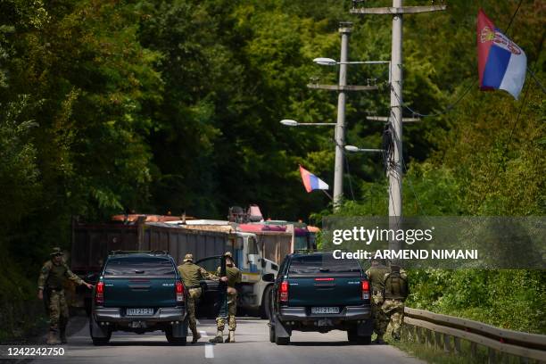 Soldiers serving in Kosovo patrol next to a road barricade set up by ethnic Serbs near the town of Zubin Potok on August 1, 2022. - Kosovo's...