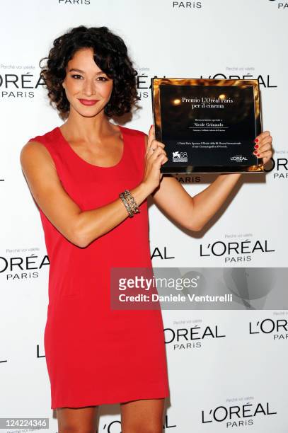 Actress Nicole Grimaudo holds her award as she attends the "L'Oreal Paris Cinema Award" Press Conference and Photocall during the 68th Venice...
