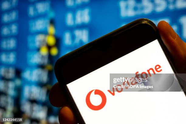 In this photo illustration, the British multinational telecommunications corporation and phone operator Vodafone logo is displayed on a smartphone...
