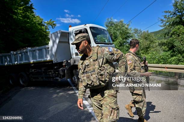 Soldiers serving in Kosovo patrol next to a road barricade set up by ethnic Serbs near the town of Zubin Potok on August 1, 2022. - Serbs in North...