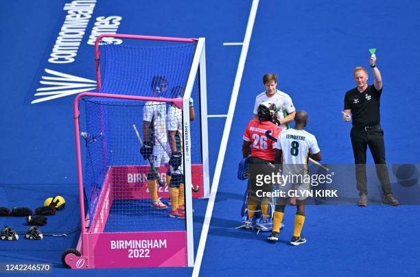 An umpire shows a green card to South Africa's Nduduzo Lembethe during the pool A hockey match between Scotland and South Africa on day four of the...