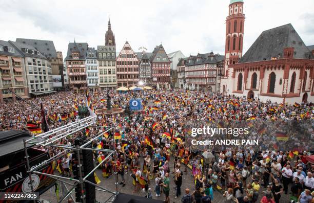 Supporters of the German national women's football team cheer as they wait to welcome players on August 1, 2022 at Roemer square in Frankfurt am...