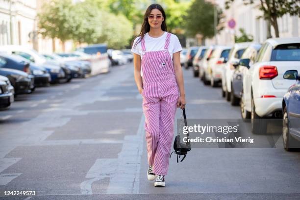 Alyssa Cordes is seen wearing red striped Carhartt overall, Comme des Garcons x Converse chucks, white tshirt Riani, black &other stories bag on June...