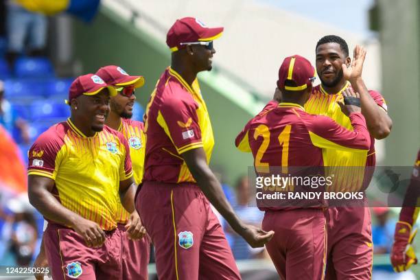 Obed McCoy , Odean Smith , Brandon King , and Jason Holder , of West Indies, celebrate the dismissal of Rohit Sharma, of India, during the second...