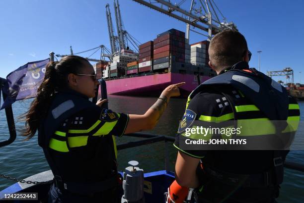 Seaport police officers observe a container ship arriving in Rotterdam's Harbour, in Rotterdam on August 1, 2022. - Drug seizures exploded in 2021 in...