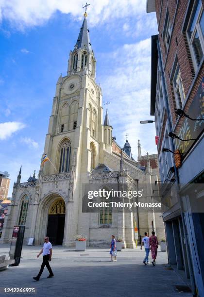 Pedesterians walk in front of the Church of Our Lady on August 2, 2022 in Sint-Truiden, Belgium. Nowadays, the Church of Our Lady of the Assumption...
