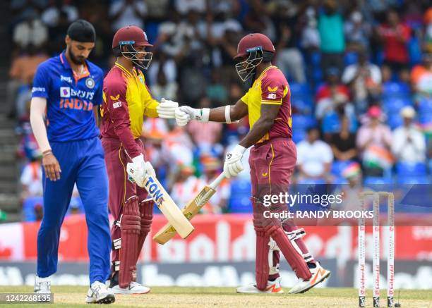 Brandon King and Kyle Mayers , of West Indies, knock gloves as Arshdeep Singh , of India, expresses disappointment during the third T20I match...
