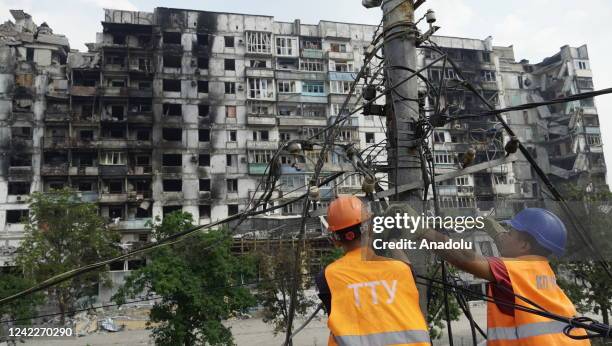 Workers repair works at damaged after the Russian shelling hit civilian settlements in Mariupol, Ukraine on August 01, 2022.