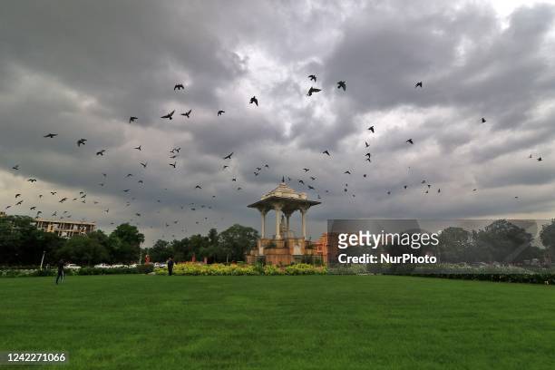 Pigeons fly during dark monsoon clouds hover over Statue circle , in Jaipur , Rajasthan , India , Tuesday, Aug 02,2022.