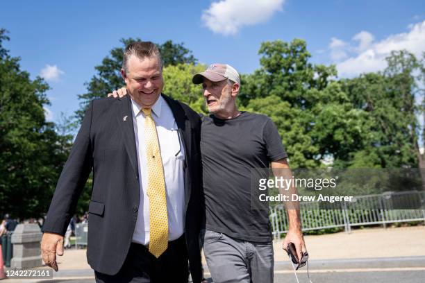 Comedian and activist Jon Stewart puts his arm around Sen. Jon Tester before the Senate vote on the PACT Act outside the U.S. Capitol August 2, 2022...