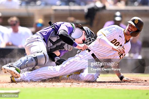 Wil Myers of the San Diego Padres scores under the tag of Brian Serven of the Colorado Rockies during the fifth inning of game one of a doubleheader...