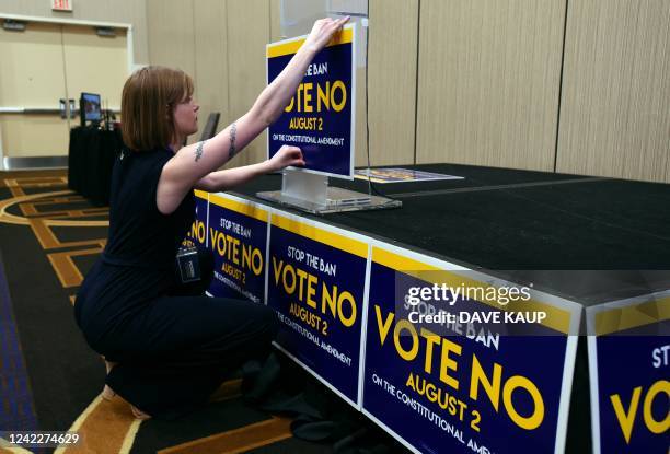 Field organizer Jae Grey places signs on the podium before the pro-choice Kansas for Constitutional Freedom primary election watch party in Overland...