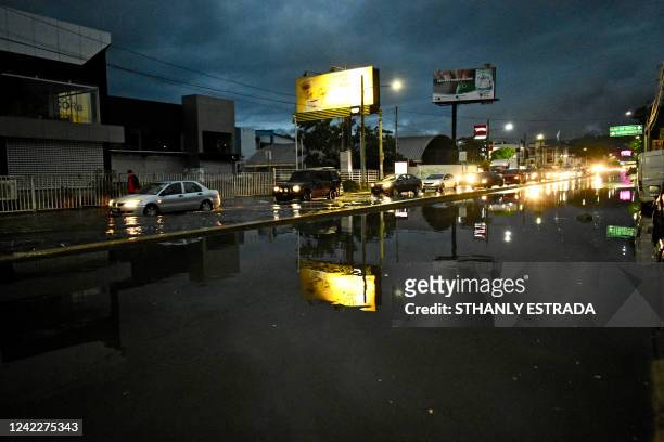 Vehicles ride along a flooded avenue in San Salvador, on July 16, 2022. A report of the World Food Program in May 2022 said more than 8.4 million...