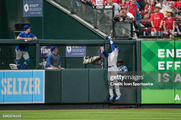 Chicago Cubs left fielder Ian Happ leaps and makes the catch over the wall stealing a home run from the batter during a game between the Chicago Cubs...