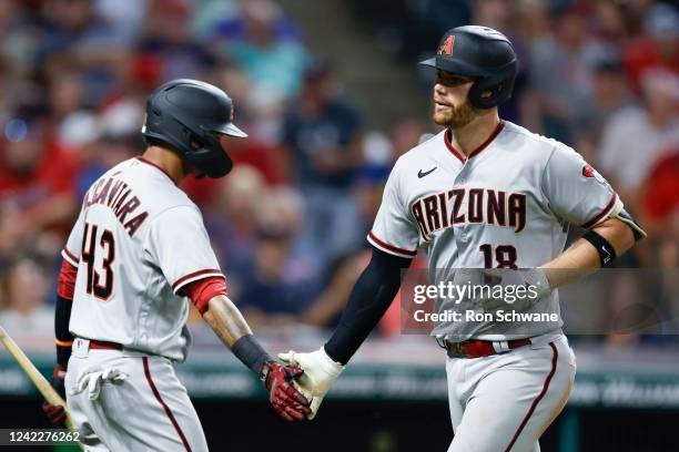 Carson Kelly of the Arizona Diamondbacks celebrates his solo home run against Enyel De Los Santos of the Cleveland Guardians with Sergio Alcantara in...