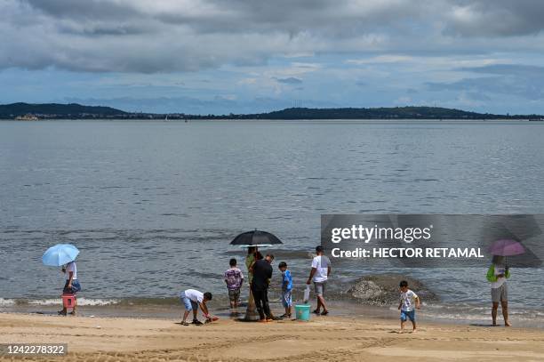 People gather at the beach in Xiamen, across Taiwan's Kinmen Islands on August 3, 2022. - US House Speaker Nancy Pelosi landed in Taiwan late on...