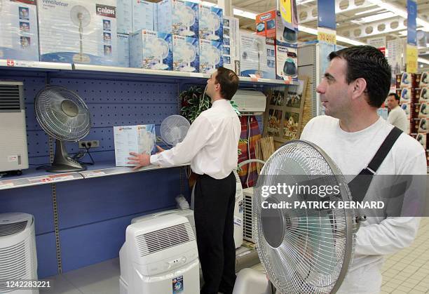 Un client d'une grande surface de la banlieue bordelaise emmène un ventilateur à la caisse, le 15 avril 2004. Dopé par la canicule de l'été dernier,...