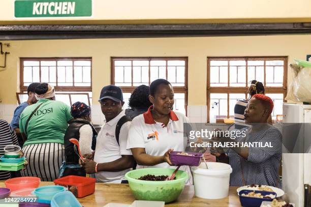 Volunteers from Meals on Wheels Community Services South Africa distribute basic food meals to flood victims in Inanda township north of Durban on...