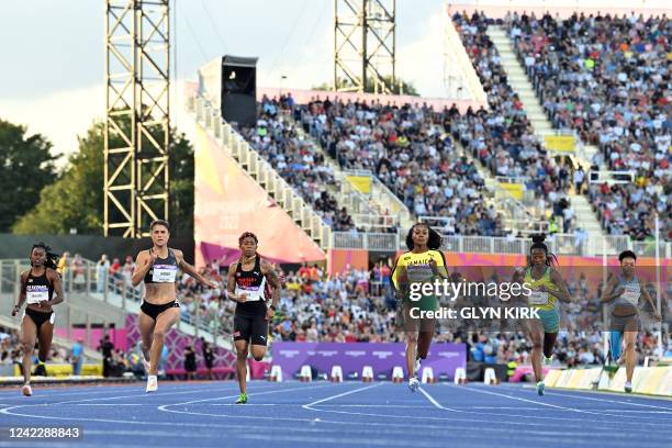 Jamaica's Elaine Thompson-Herah crosses the finish line in first place followed by New Zealand's Zoe Hobbs and Trinidad and Tobago's Michelle-Lee...