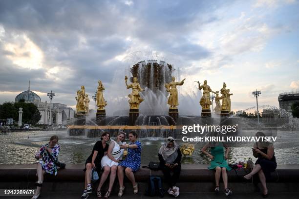 Women sit on the Druzhba Narodov fountain at the All-Russia Exhibition Centre in Moscow on August 3 as the air temperature approaches 29 degrees...