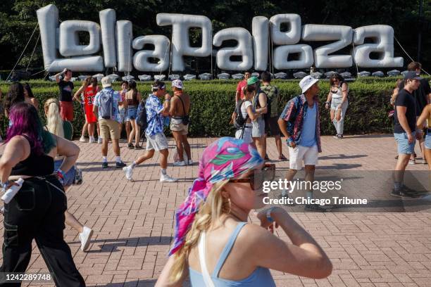 Attendees walk past a Lollapalooza sign during the first day of the annual music festival in Chicago&apos;s Grant Park on July 29, 2021.