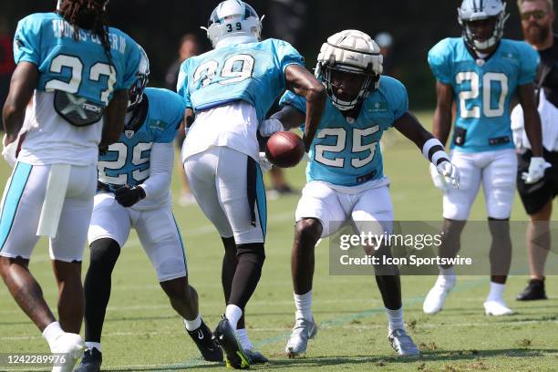 Carolina Panthers safety Xavier Woods punches the ball free during a secondary drill during the Carolina Panthers training camp at Wofford College in...