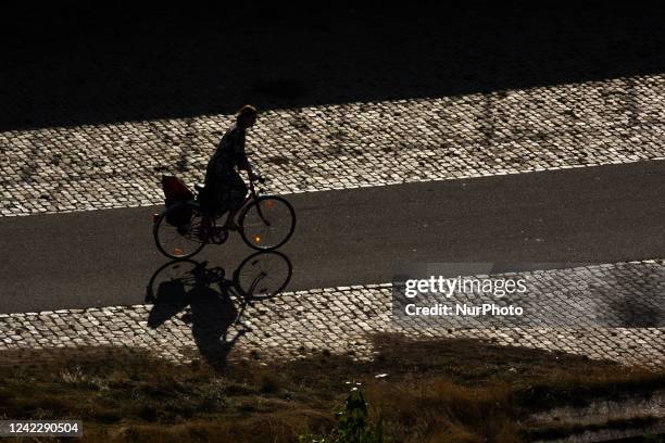 Woman is on the bicycle at the bank of Rhine river in Cologne, Germany on August 3, 2022 as temperture reaches to 32 degrees Celsius