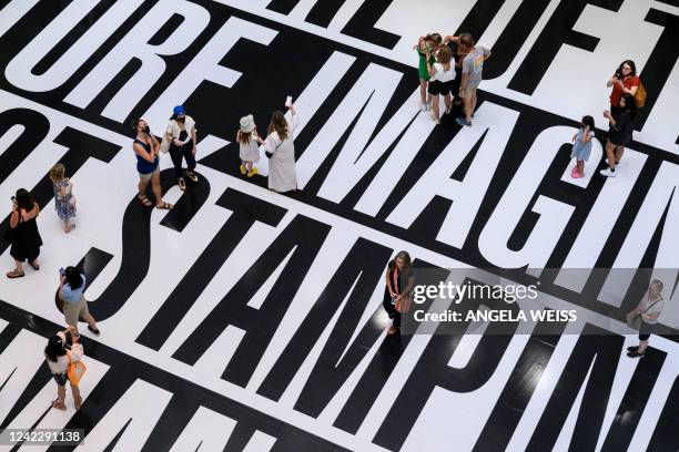 Visitors look at the "Thinking of You. I Mean Me. I Mean You." installation by US artist Barbara Kruger at The Museum of Modern Art in New York on...