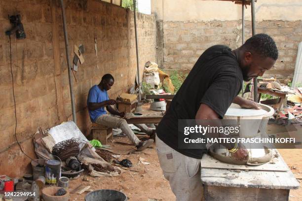 Rodolphe Teko , owner of 'Tcha-Tcha Business', a small company that builds 'improve ovens' to limit the use of charcoal while cooking, works at his...