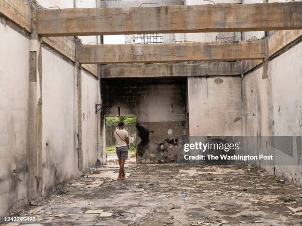 Young woman walks through a ruined building in Honiara's Chinatown, which was targeted during riots last November.