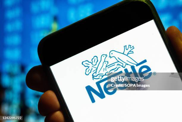 In this photo illustration, the wiss multinational food and drink processing conglomerate corporation Nestlé logo is displayed on a smartphone screen.