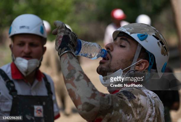 Member of the Iranian Red Crescent Society drinks water as he prepares to search for a body of a flood victim, five days after a sudden flooding in...