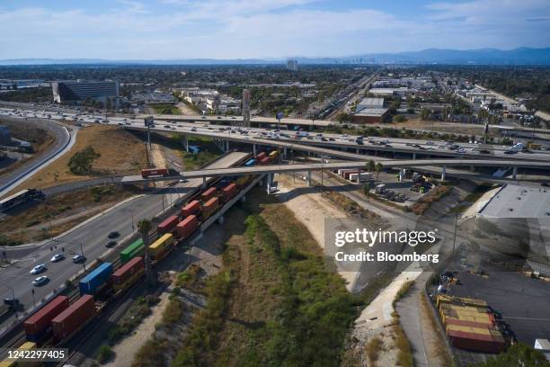 Freight containers pass under a highway in Compton, California, US, on Tuesday, Aug. 2, 2022. Some roofs in Los Angeles South Bay are helping reflect...