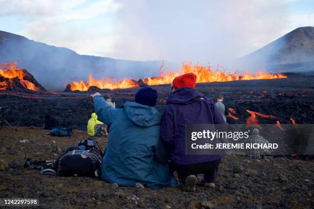 People look at the lava erupting and flowing at the scene of the newly erupted volcano at Grindavik, Iceland on August 3, 2022. A volcano erupted on...