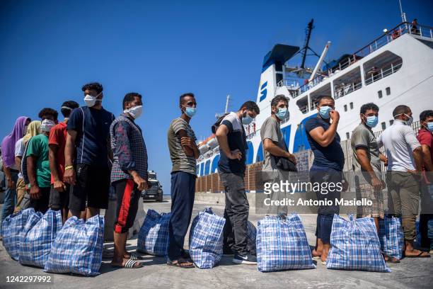 Migrants wait to board a commercial ship before being transferred from the so-called "Hotspot" operational facility, containing over 1,500 people, on...