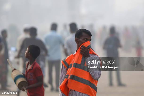 Worker covers his nose with his jacket amid an air polluted atmosphere in Dhaka. Most steel re-rolling mills in and around the capital have been...