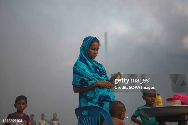 Pregnant woman purchases bananas amid an air polluted atmosphere in Dhaka. Most steel re-rolling mills in and around the capital have been running...