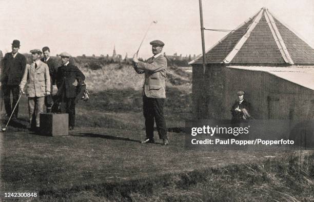 Vintage photograph featuring Scottish professional golfers Sandy Herd teeing off, watched by Ben Sayers Junior , during The British Open Championship...