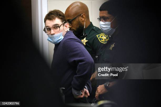Nikolas Cruz is led from the courtroom after he was sworn in and waved his right to be present at the school while the jury walks through the crime...