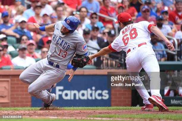 James Naile of the St. Louis Cardinals tags out David Bote of the Chicago Cubs at home plate in the seventh inning in game one of a double header at...