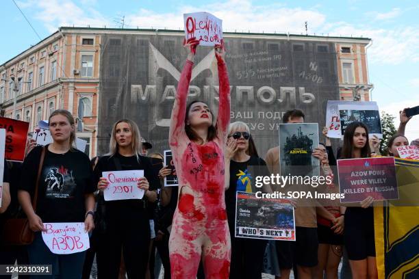 Protesters hold placards expressing their opinion during the protest in support of the soldiers of the Azov battalion, who were tortured by the...