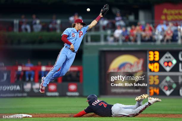 Maikel Franco of the Washington Nationals steals second base as the ball sails over the head of shortstop Bryson Stott of the Philadelphia Phillies...