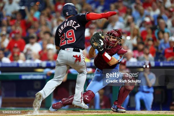 Catcher J.T. Realmuto of the Philadelphia Phillies gets set to tag out Yadiel Hernandez of the Washington Nationals who attempted to score on a fly...
