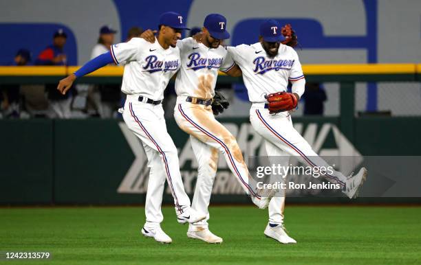 Bubba Thompson of the Texas Rangers celebrates with teammates Leody Taveras and Adolis Garcia after the Rangers defeated the Chicago White Sox 3-2 at...