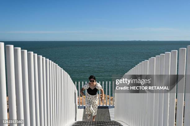 Tourist walks on a scenic spot bridge on Pingtan island, one of mainland China's closest point from Taiwan, in Fujian province on August 5, 2022. -...