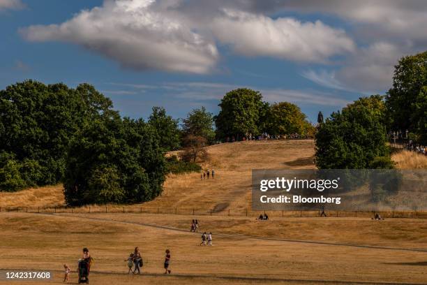 Visotrs walk across dry grass areas in Greenwich Park in the Greenwich district of London, UK, on Wednesday, Aug. 3, 2022. Across London and most of...