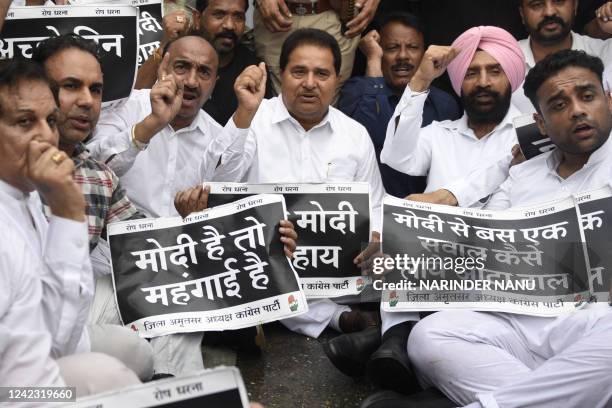 Congress party activists and supporters shout slogans and display placards during a protest against the central government for inflation,...