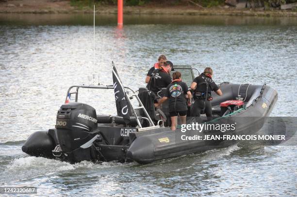 Members of the Sea Shepherd NGO looks for a beluga whale, which was spotted while swimming up France's Seine river, near a lock in...