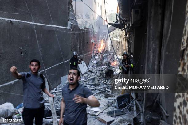 Rescuers and firefighters put out a fire amid the destruction following an Israeli air strike on Gaza City, on August 5, 2022. - The Israeli military...