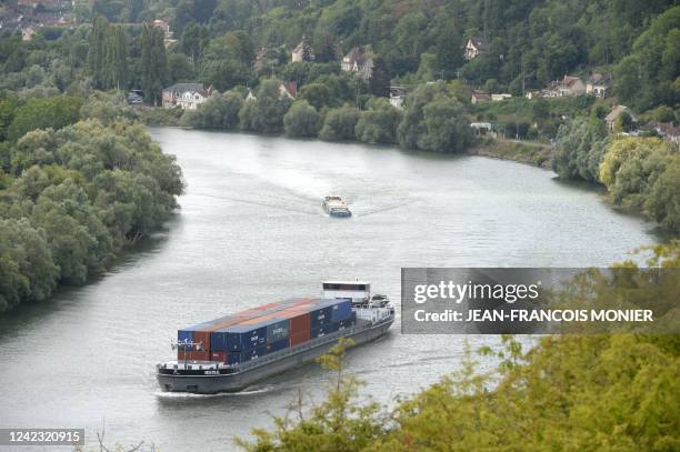 Barges tansporting shipping containers sail on the Seine river where a beluga whale was spotted, near a lock in Courcelles-sur-Seine, northwestern...
